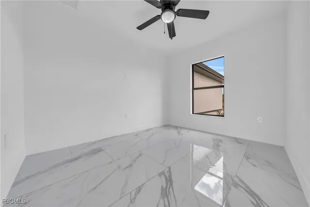 an empty room with a window and a ceiling fan