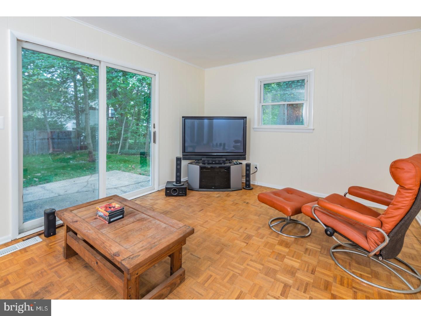 73 Robert Road Princeton, NJ 08540 - Photo 12 of 24 a living room with furniture a flat screen tv and a floor to ceiling window