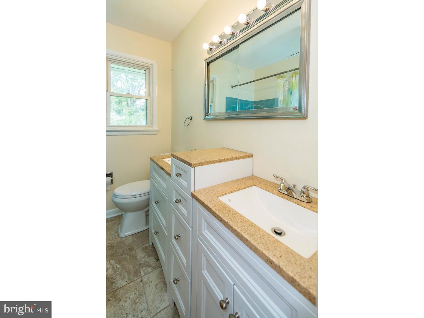 73 Robert Road Princeton, NJ 08540 - Photo 21 of 24 a bathroom with a granite countertop toilet a sink and mirror