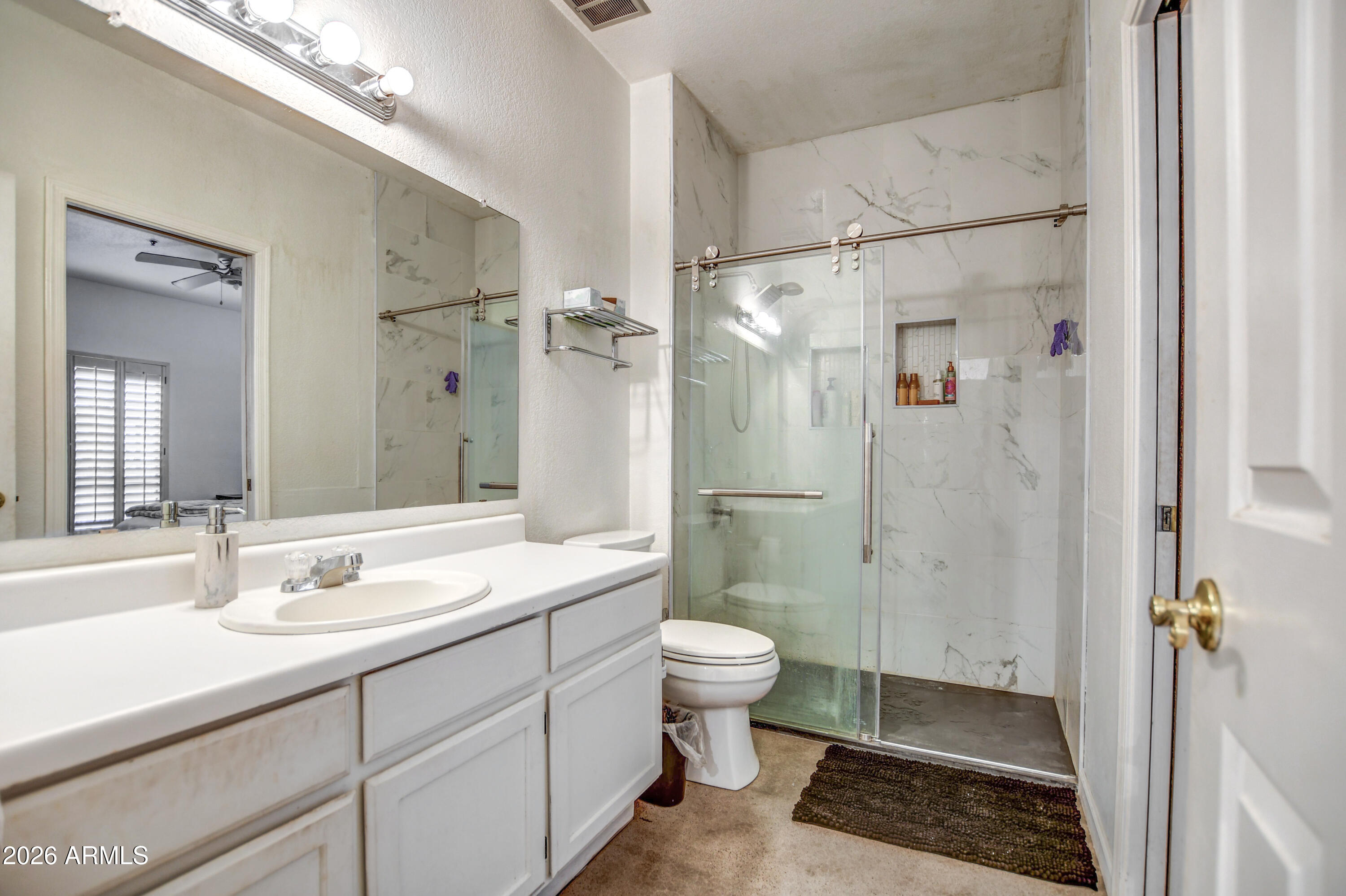 100 East Fillmore Street, Unit 117 Phoenix, AZ 85004 - Photo 15 of 20 a bathroom with a double vanity sink toilet mirror and shower