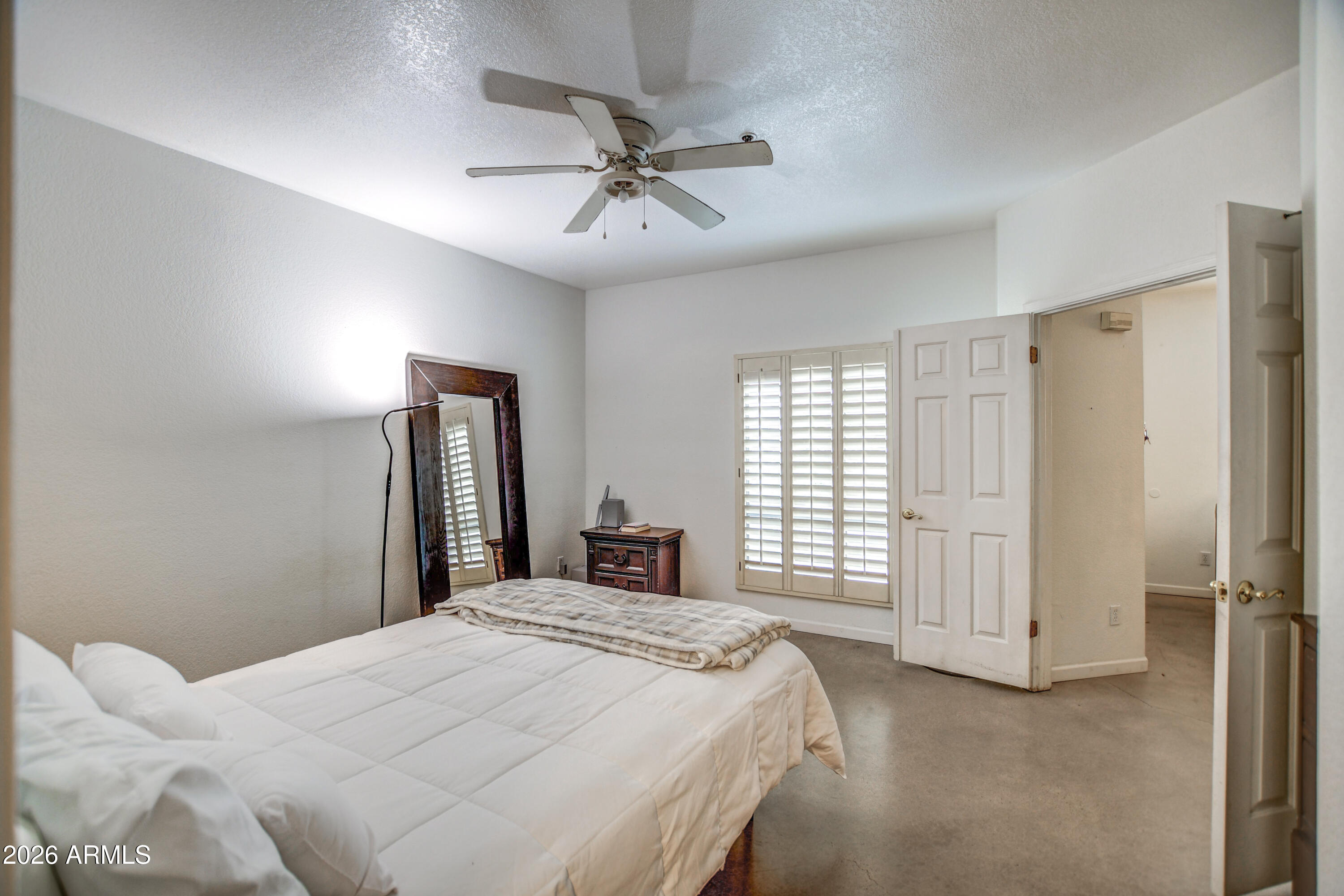 100 East Fillmore Street, Unit 117 Phoenix, AZ 85004 - Photo 17 of 20 a bedroom with a large bed and a chandelier