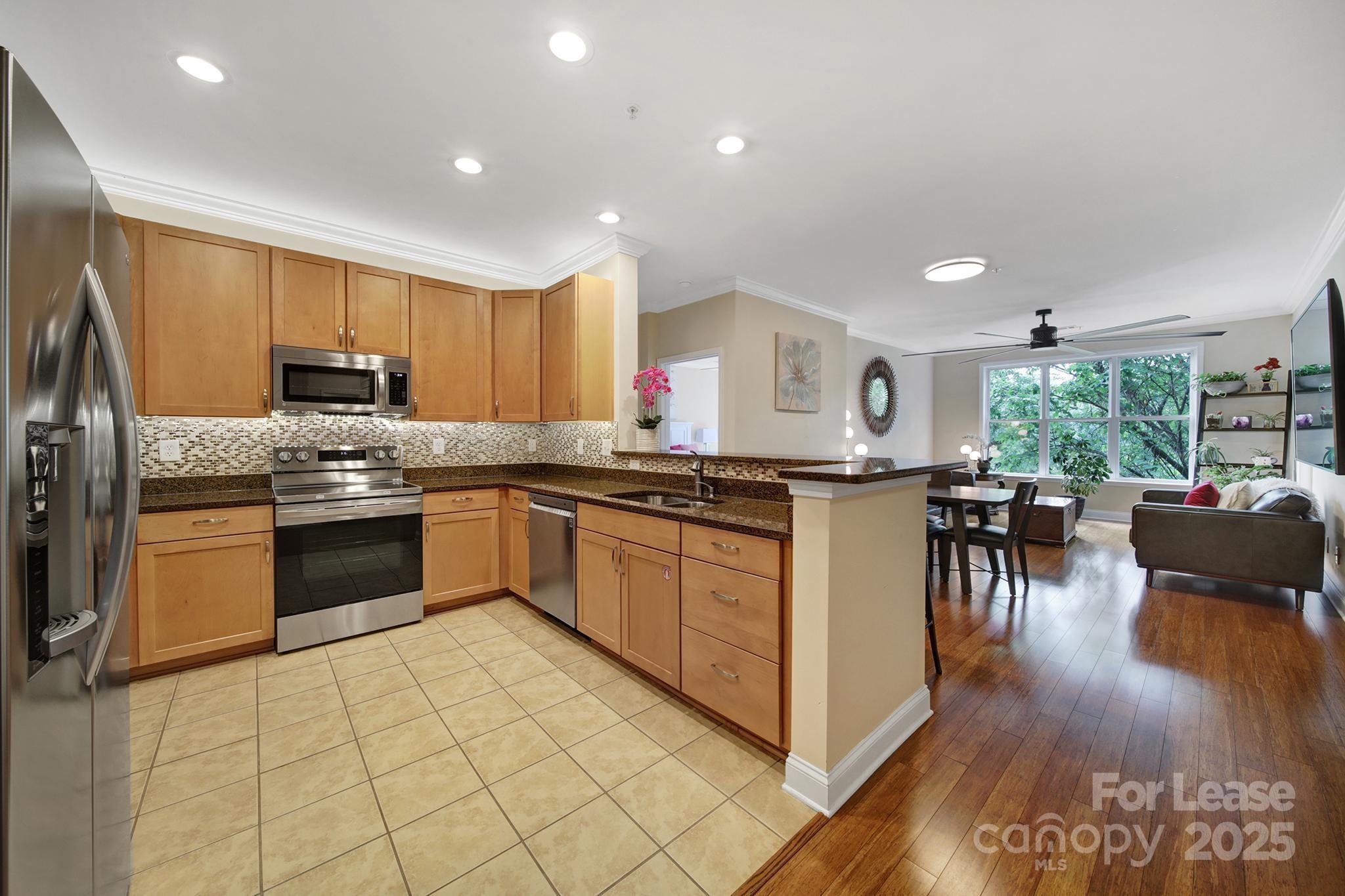 a kitchen with granite countertop a stove top oven a sink a dining table and chairs
