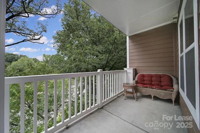 a view of a balcony with wooden floor and fence