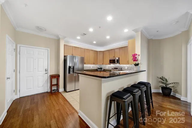a kitchen with stainless steel appliances granite countertop a refrigerator and a sink