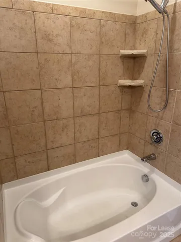 a white bath tub sitting in a bathroom and a sink