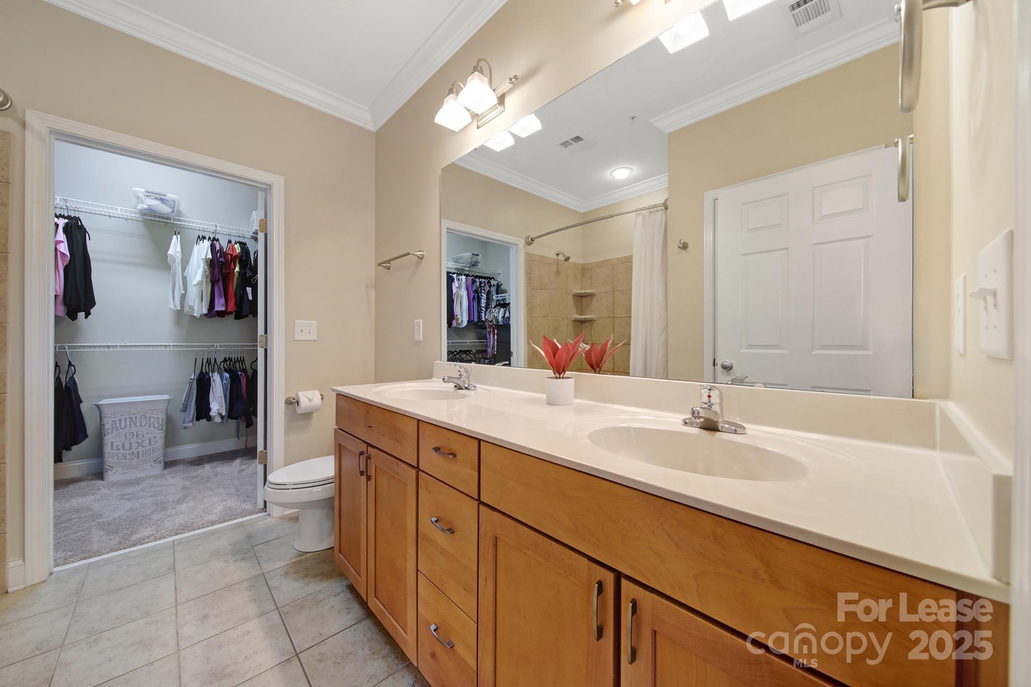 1000 East Woodlawn Road Charlotte, NC 28209 - Photo 8 of 29 a spacious bathroom with a sink a vanity and a mirror