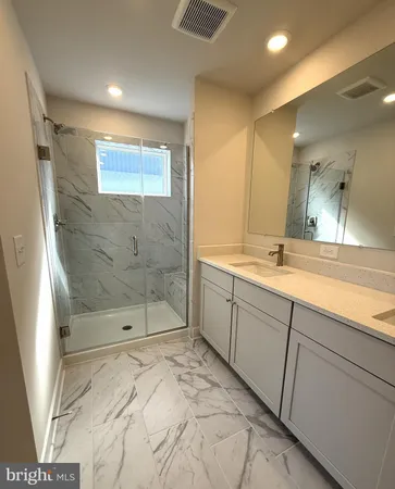 a bathroom with a shower sink and mirror