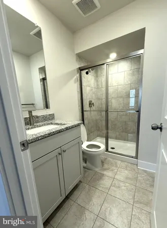 a bathroom with a granite countertop sink toilet and shower