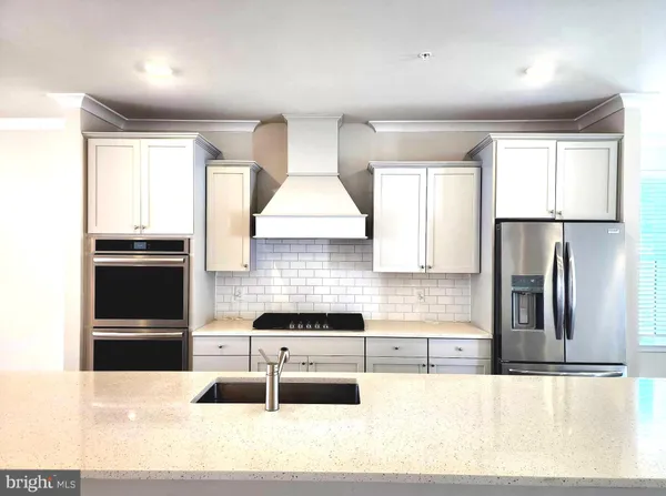 a kitchen with stainless steel appliances kitchen island granite countertop a refrigerator and a stove top oven