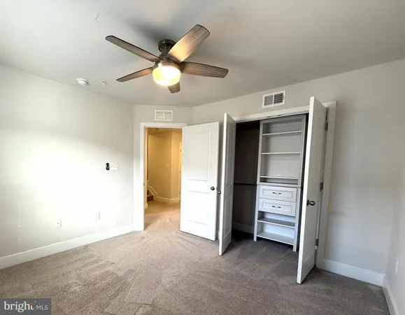 a view of room with closet and ceiling fan