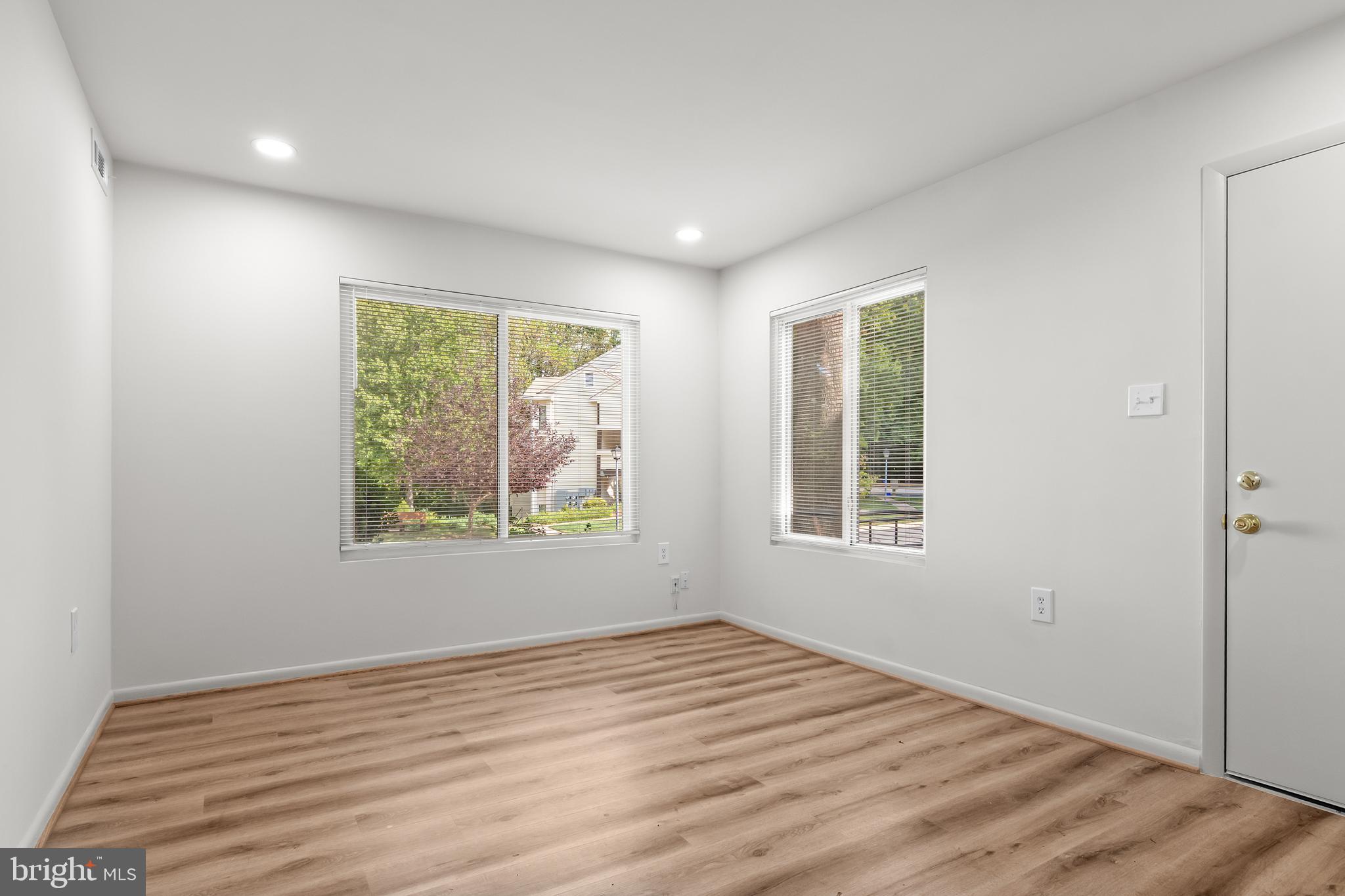 10330 Luria Commons Court, Unit 1B Burke, VA 22015 - Photo 12 of 24 a view of an empty room with wooden floor and a window