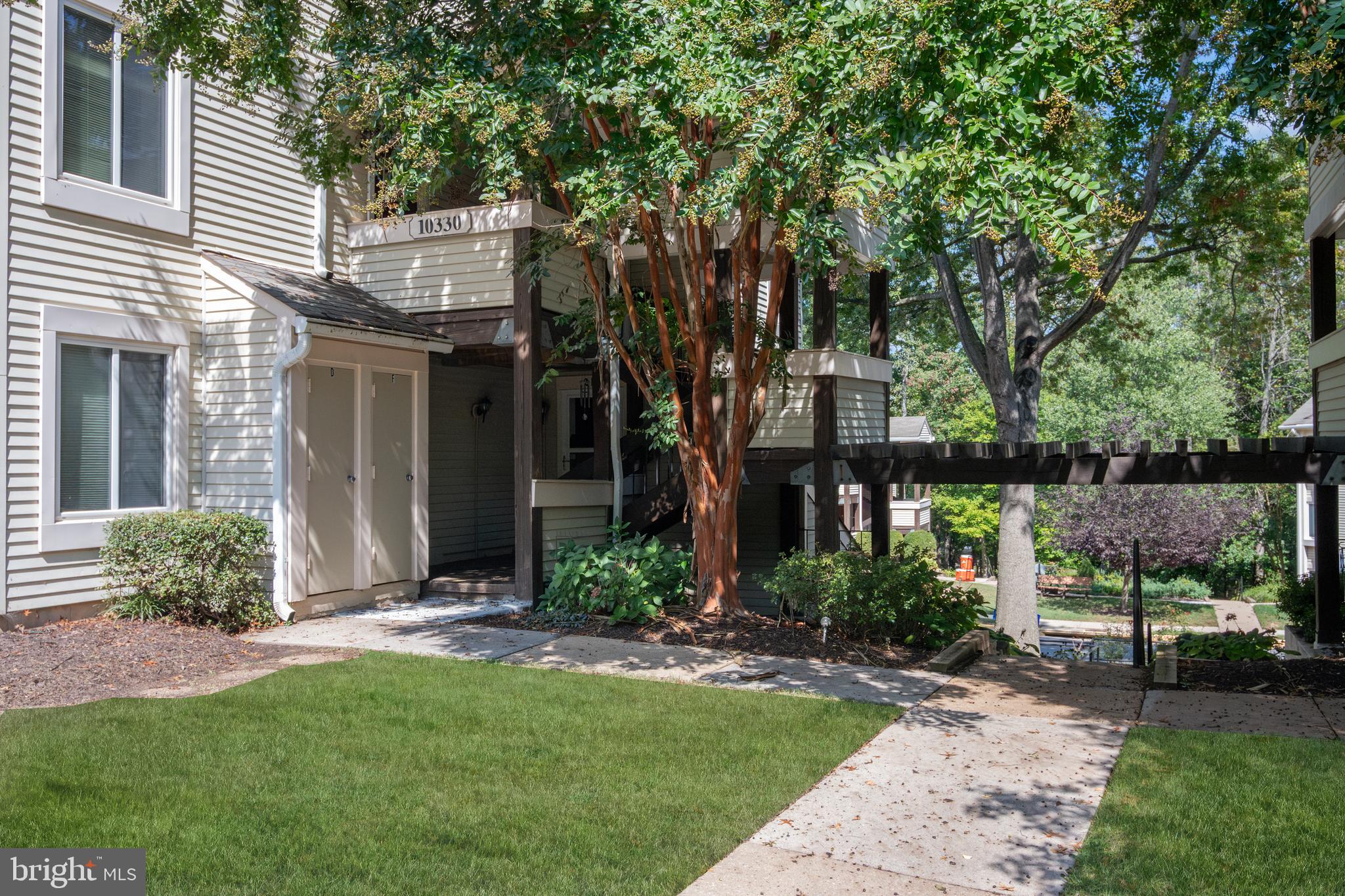 10330 Luria Commons Court, Unit 1B Burke, VA 22015 - Photo 6 of 24 a view of a house with brick walls and a large tree