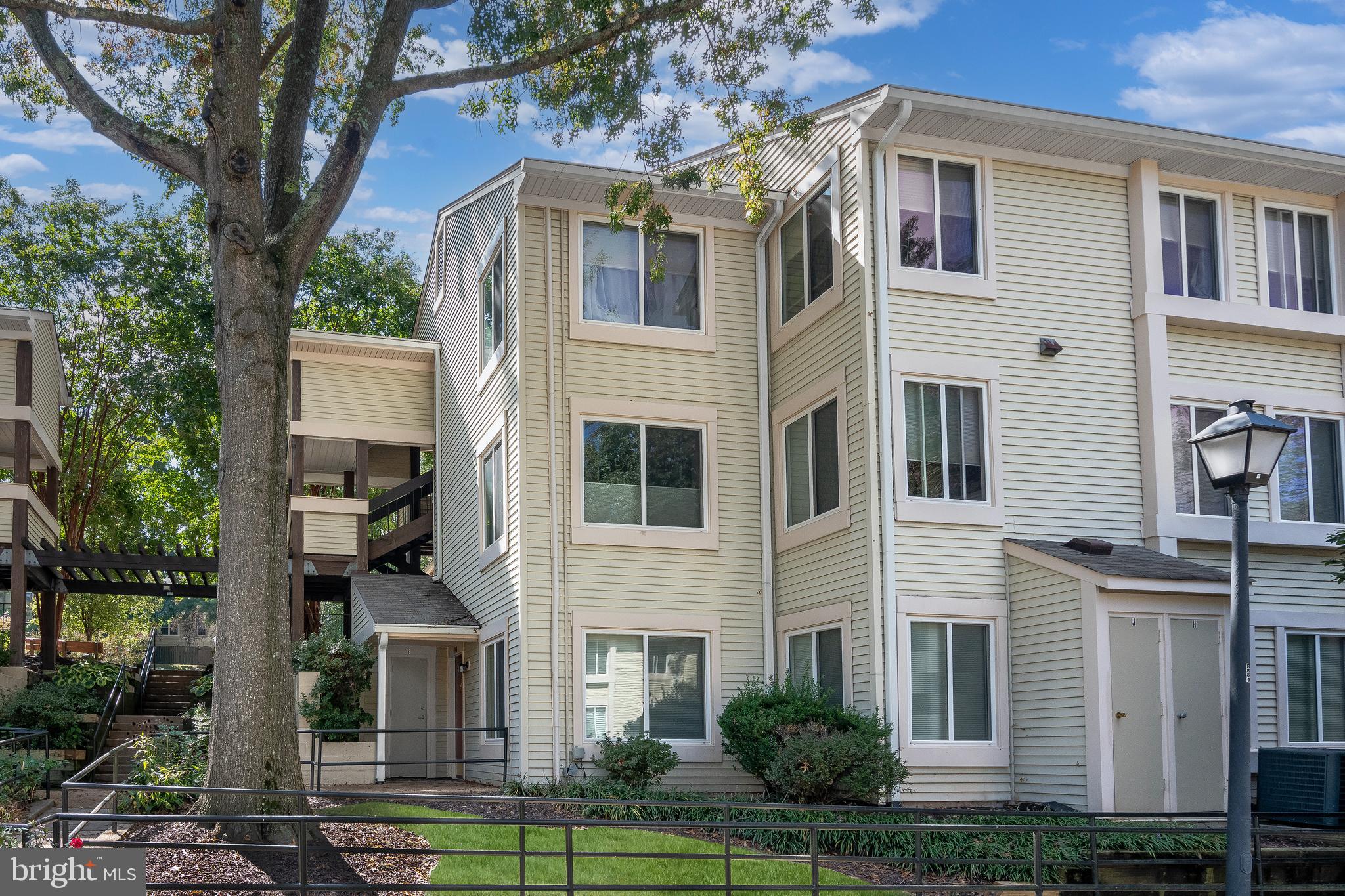 10330 Luria Commons Court, Unit 1B Burke, VA 22015 - Photo 7 of 24 a front view of a building with a garden and trees