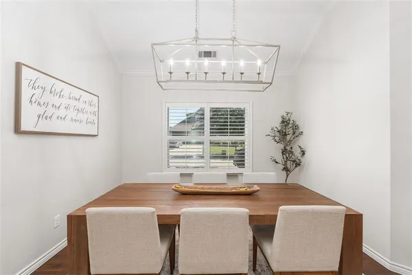 a view of a dining room with a table and chairs