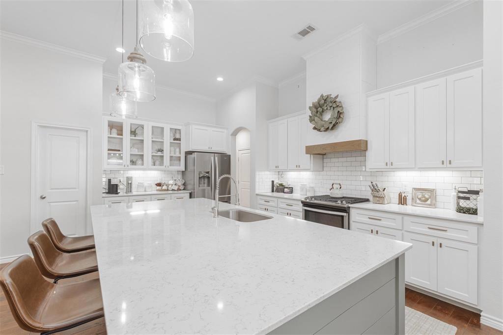 400 Prairie Run Aledo, TX 76008 - Photo 24 of 36 a kitchen with stainless steel appliances granite countertop a stove a sink a refrigerator and white cabinets with wooden floor