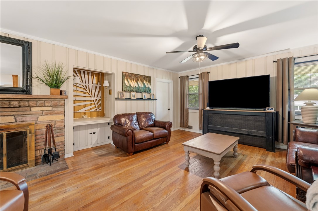 1105 Greenacres Anderson, SC 29621 - Photo 6 of 46 A classic fireplace with a stone surround anchors this inviting living space with warm hardwood floors.