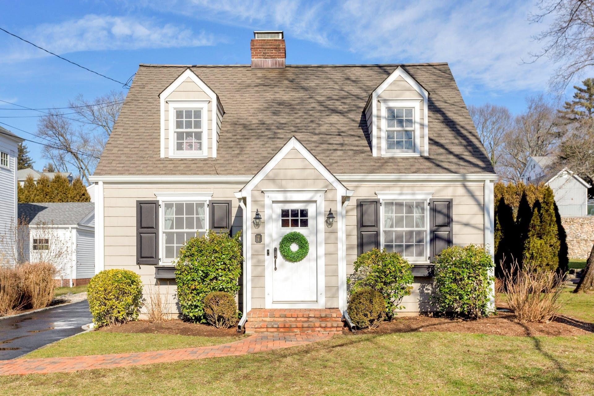 7 Devon Road Darien, CT 06820 - Photo 1 of 29 a view of a brick house with large windows and a large tree