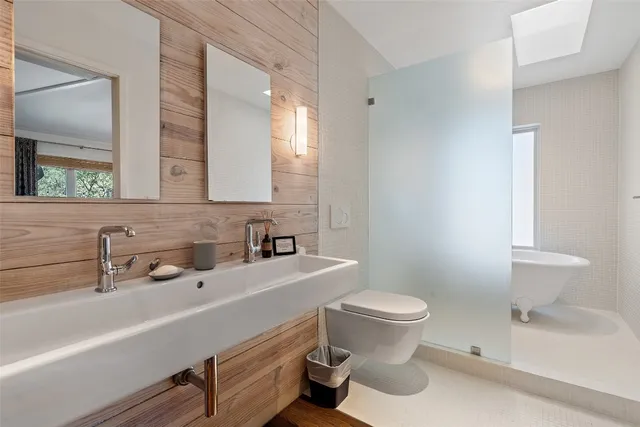 a bathroom with a sink a toilet and a mirror