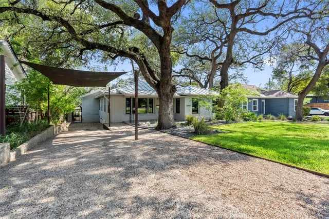 a view of a house with a tree and plants