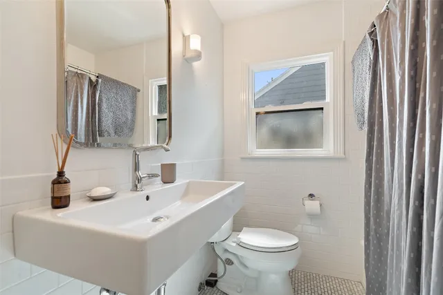 a bathroom with a sink toilet and mirror
