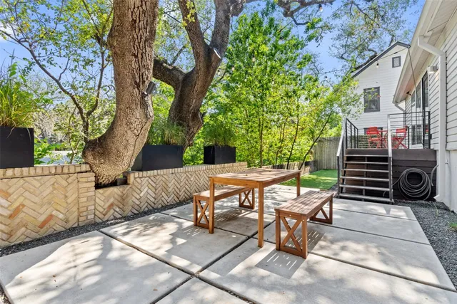 a view of a patio with table and chairs and floor to ceiling window
