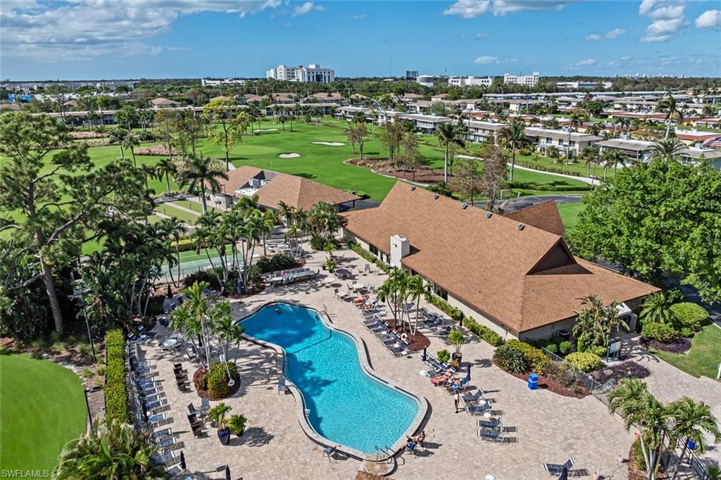 136 Harrison Road, Unit 1 Naples, FL 34112 - Photo 24 of 29 Extensive outdoor amenity area featuring a freeform swimming pool, paver deck, and surrounding lounge seating