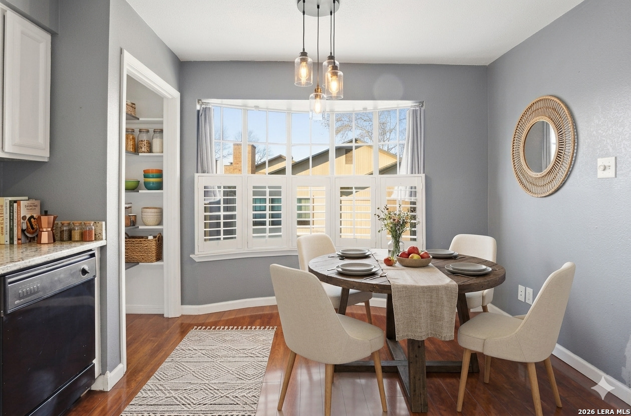 7711 Callaghan Road, Unit 404 San Antonio, TX 78229 - Photo 13 of 39 a dining room with furniture a chandelier and wooden floor