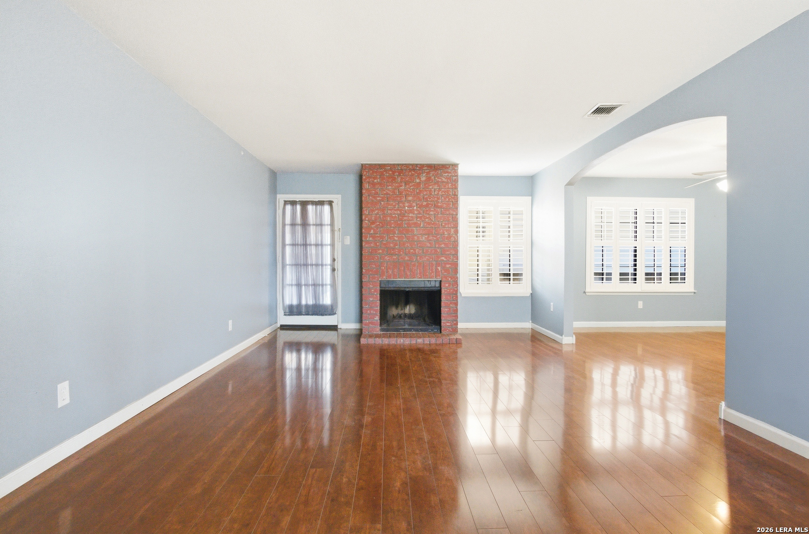 7711 Callaghan Road, Unit 404 San Antonio, TX 78229 - Photo 2 of 39 an empty room with wooden floor and fireplace
