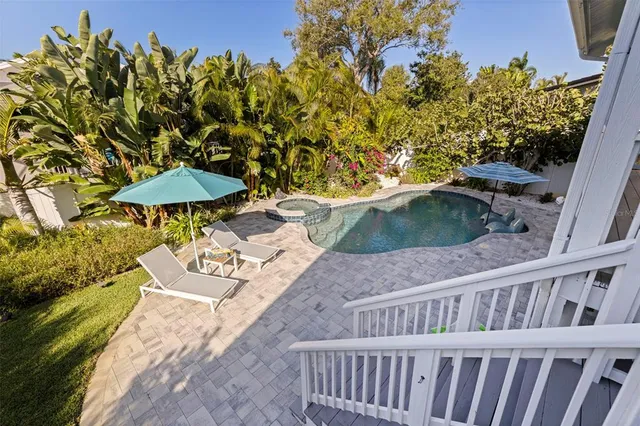 a roof deck with table and chairs under an umbrella