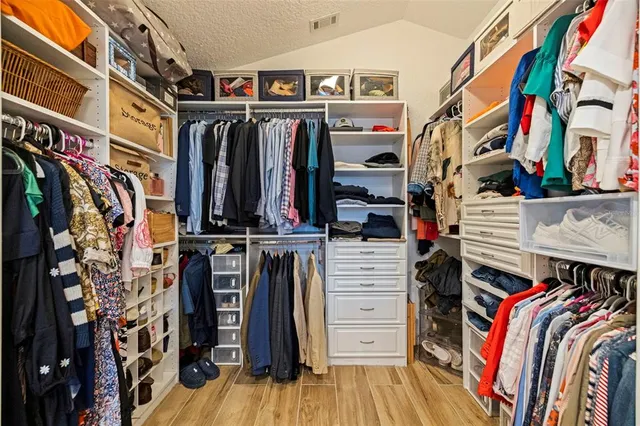a view of walk in closet with clothes and shoes