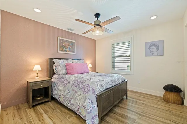 a bedroom with a bed and a ceiling fan