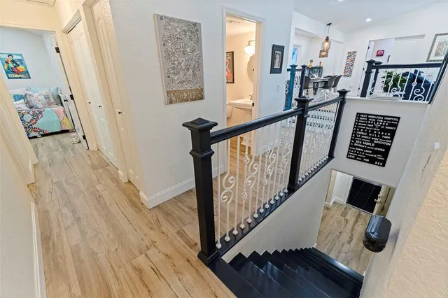 a view of a hallway with wooden floor and stairs
