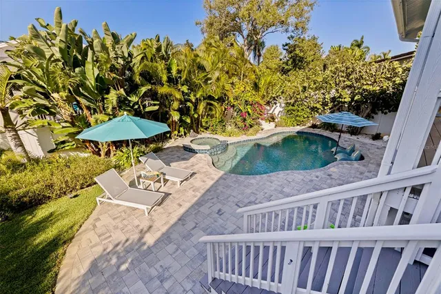 a roof deck with table and chairs and potted plants