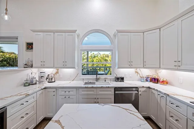 a kitchen with cabinets appliances a sink and a window