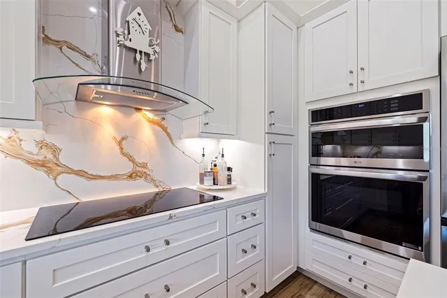 a kitchen with white cabinets and appliances
