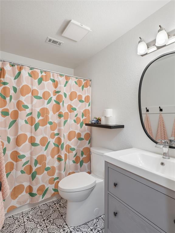 12724 Carpenter Lane Rhome, TX 76078 - Photo 20 of 37 Bathroom featuring decorative floor tile, a modern vanity with integrated sink, and an oval-framed mirror