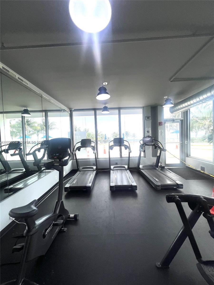 100 Lincoln Road, Unit 430 Miami Beach, FL 33139 - Photo 17 of 17 a living room with furniture gym equipment and a large window