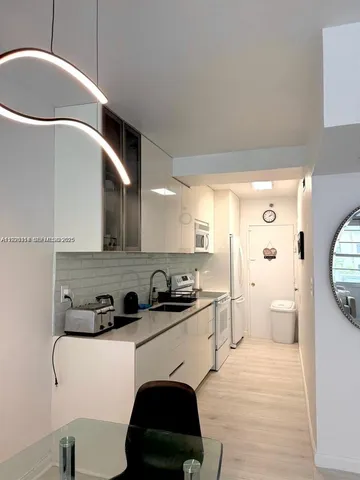 a kitchen with stainless steel appliances a sink a stove a refrigerator and cabinets