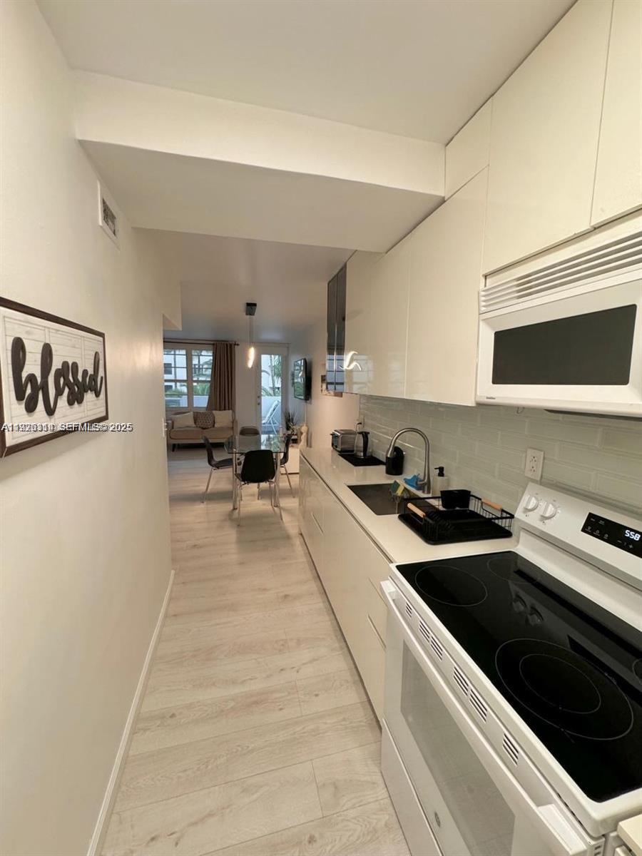 100 Lincoln Road, Unit 430 Miami Beach, FL 33139 - Photo 8 of 17 a kitchen with stainless steel appliances a stove a sink and a refrigerator