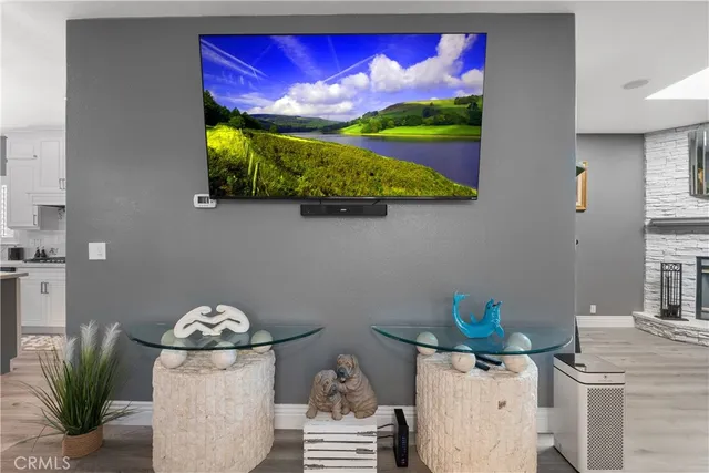 a kitchen with stainless steel appliances kitchen island granite countertop a sink dishwasher and white cabinets with wooden floor