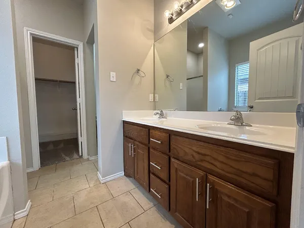 a bathroom with a double vanity sink and a mirror