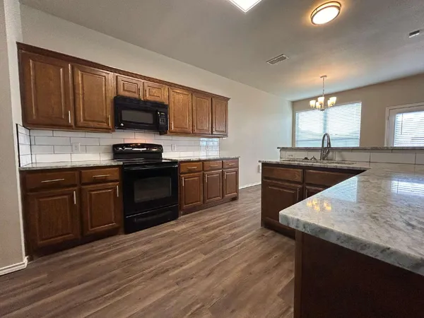 a kitchen with stainless steel appliances granite countertop a sink stove and microwave