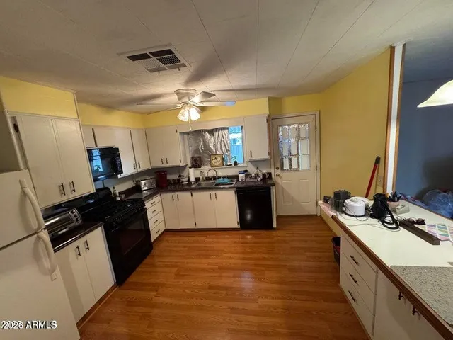 a large kitchen with stainless steel appliances kitchen island granite countertop a stove and a sink