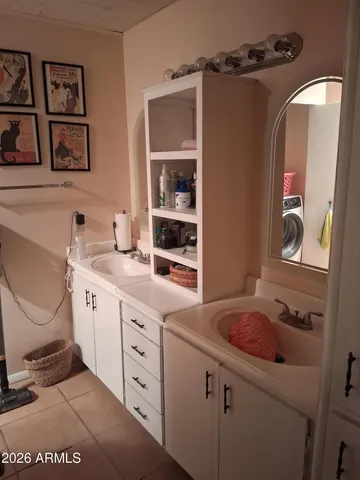 a spacious bathroom with a double vanity sink a mirror a window and a shower
