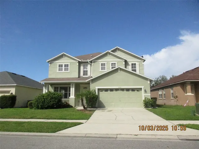 a front view of a house with a garden and parking