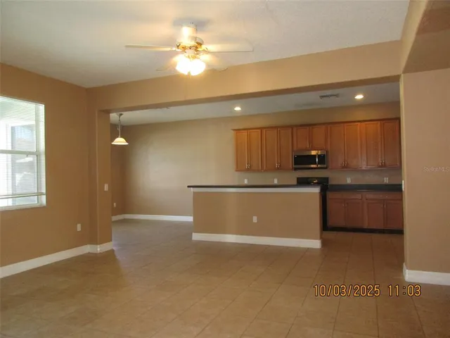 a view of kitchen with stainless steel appliances cabinets and a window