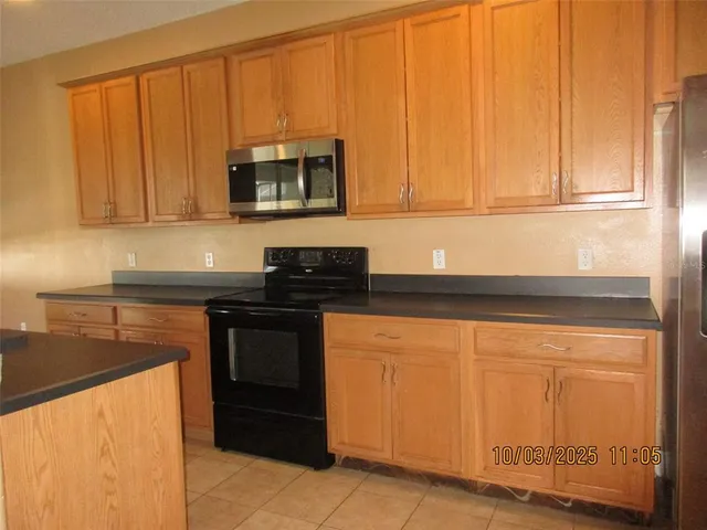 a kitchen with stainless steel appliances granite countertop white cabinets and a refrigerator