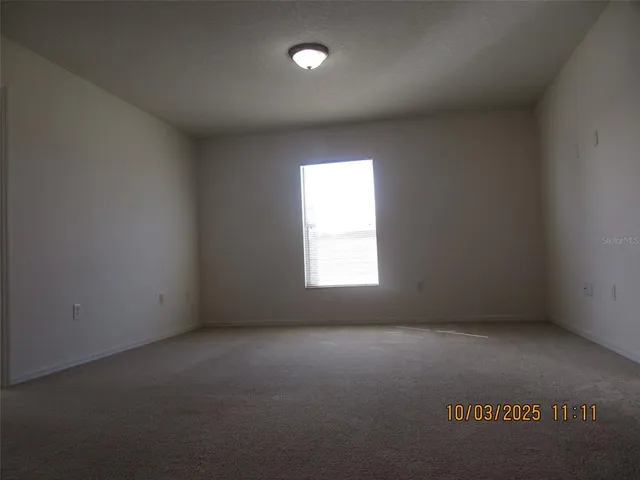 en empty room with windows and fan