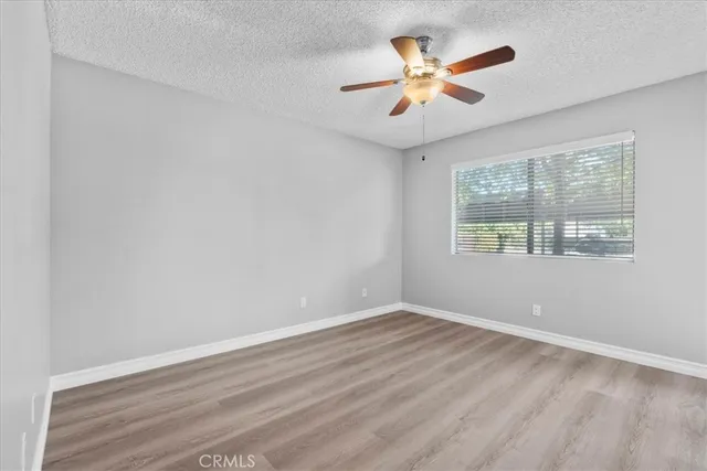 an empty room with window and ceiling fan