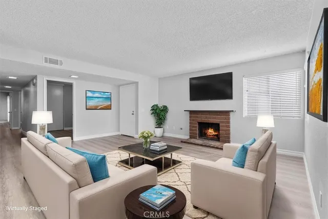 a living room with furniture a fireplace and a flat screen tv